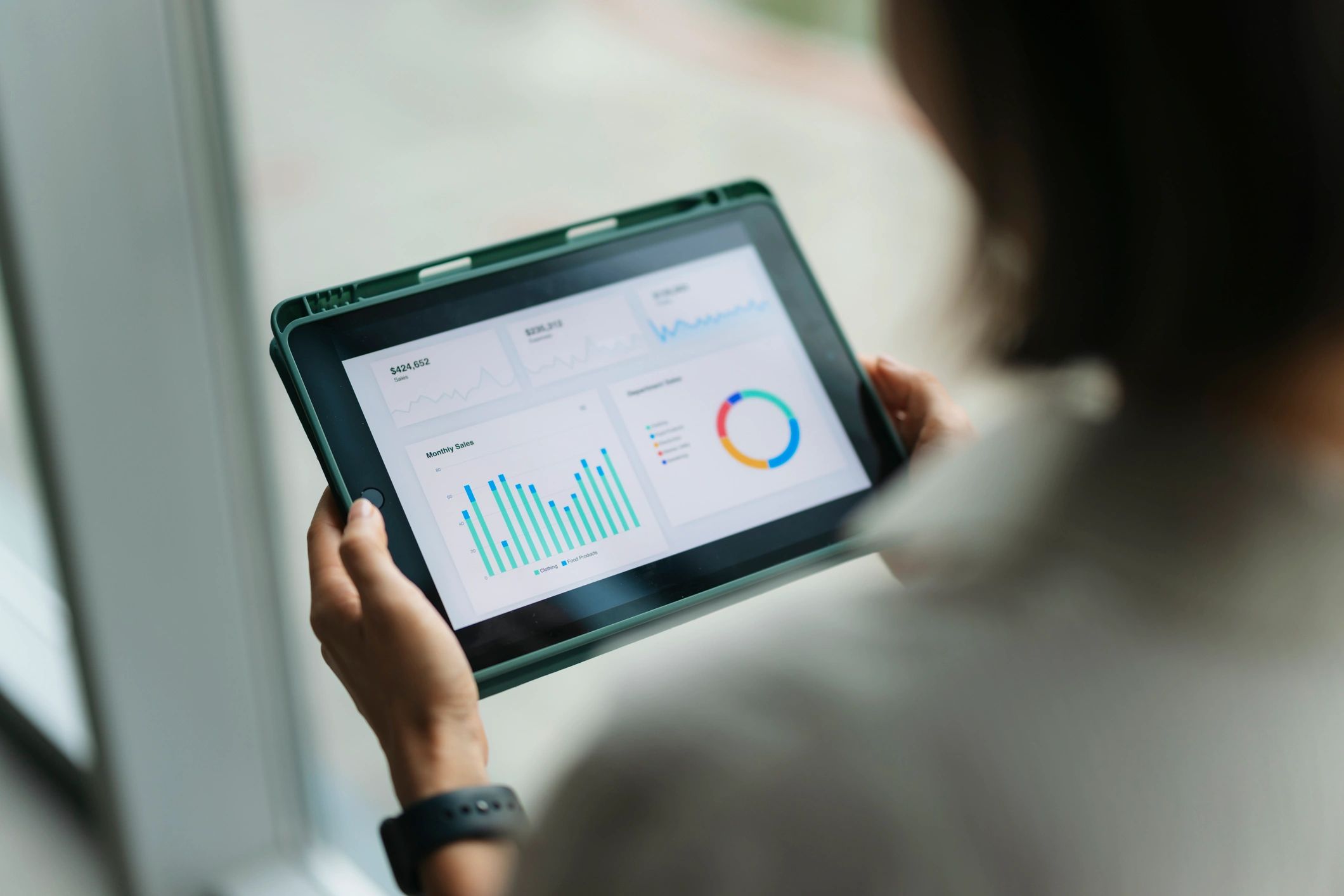 Person reviewing stock market charts on a tablet